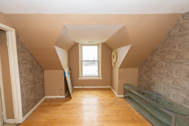 bonus room with light hardwood / wood-style flooring and vaulted ceiling