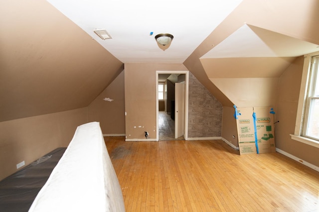 bonus room with light hardwood / wood-style floors and vaulted ceiling