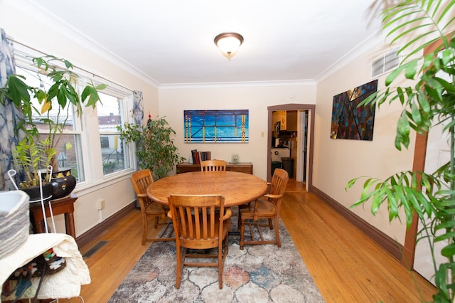 dining space with wood-type flooring and ornamental molding