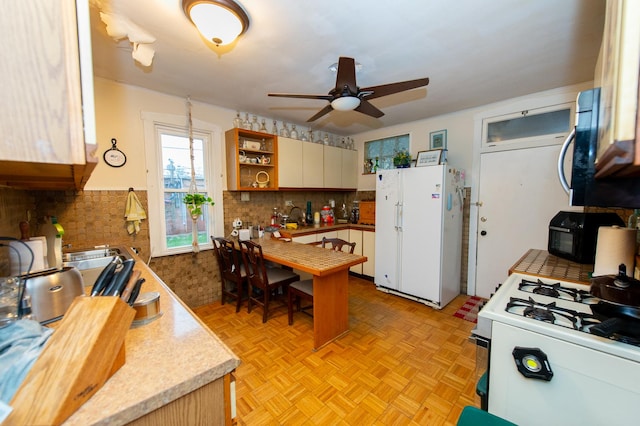 kitchen with ceiling fan, white cabinetry, white appliances, and light parquet flooring