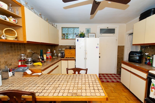 kitchen with white appliances, backsplash, white cabinetry, and light parquet flooring