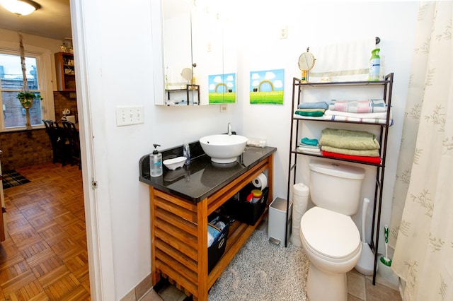 bathroom featuring vanity, toilet, parquet floors, and walk in shower