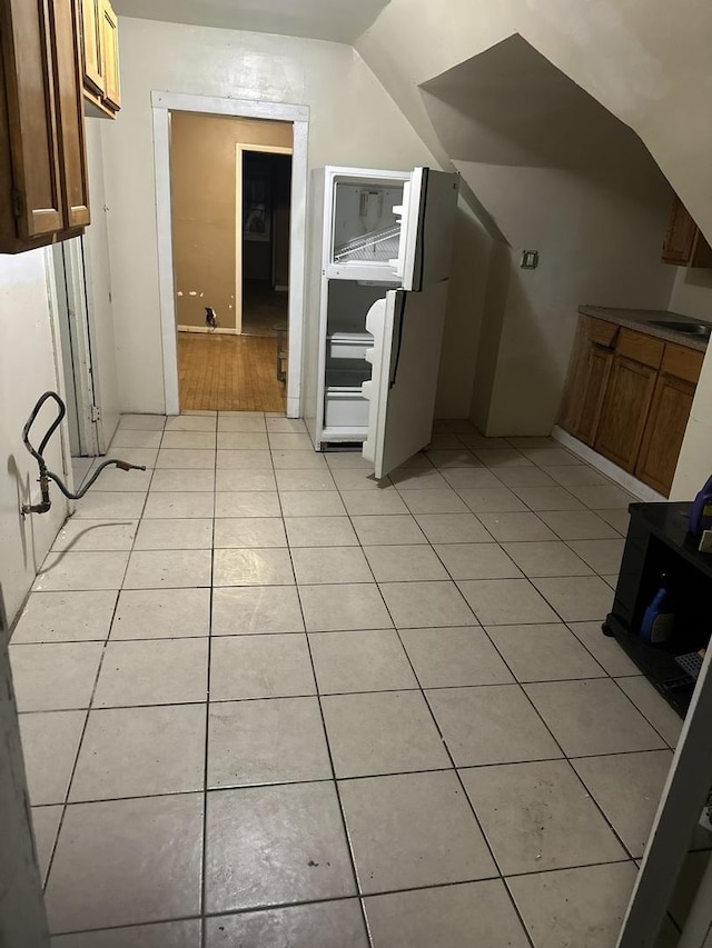 additional living space with light tile patterned floors and vaulted ceiling