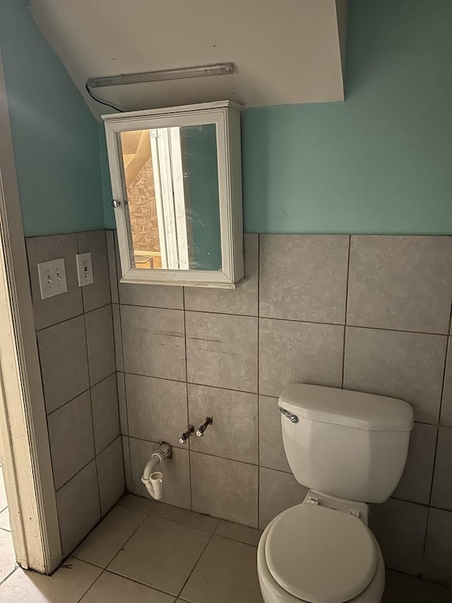 bathroom with tile patterned floors, tile walls, and toilet