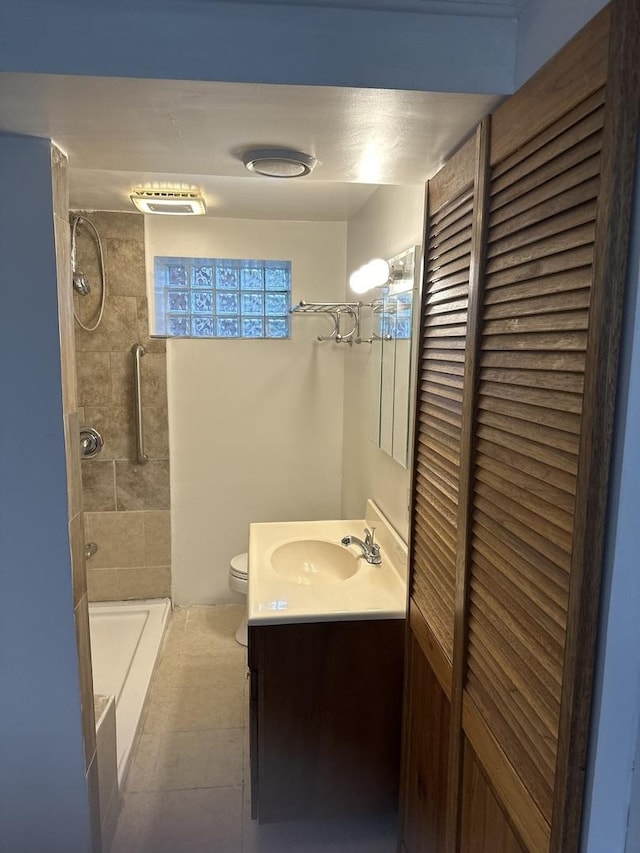 bathroom featuring toilet, vanity, and tiled shower