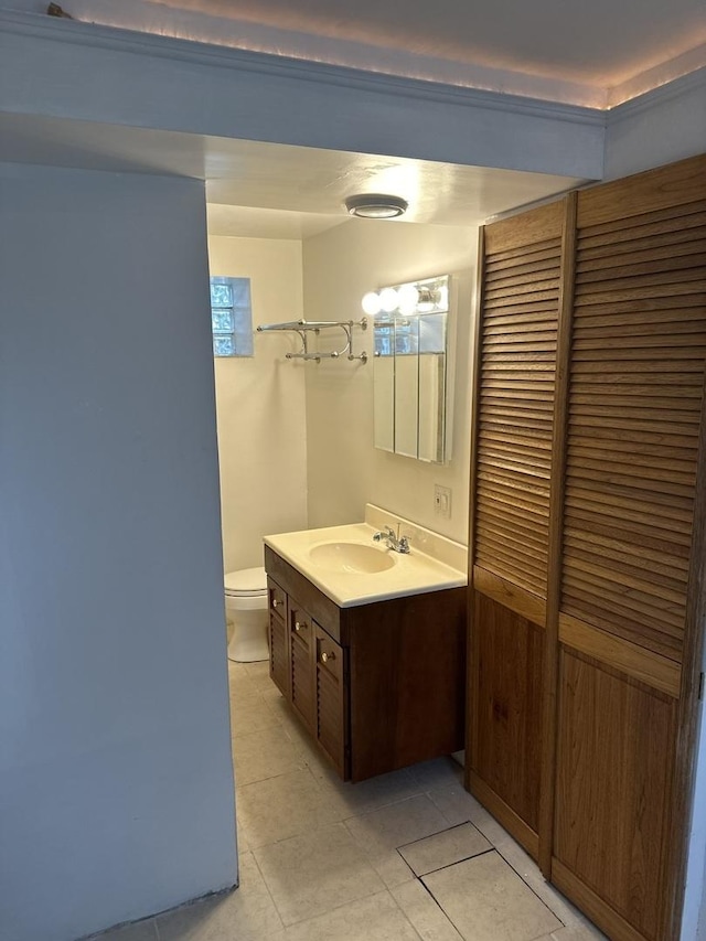 bathroom with tile patterned flooring, vanity, and toilet