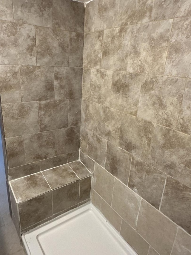 interior details with a tile shower