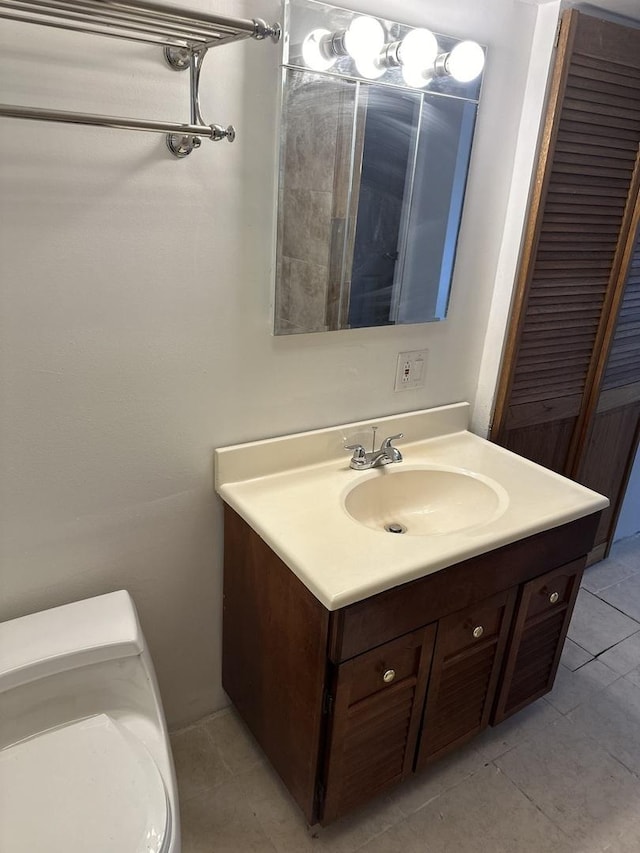 bathroom with tile patterned flooring, vanity, and toilet