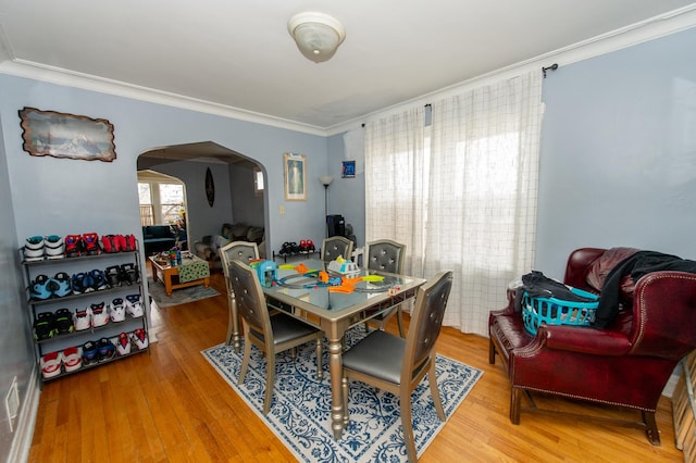 dining space with hardwood / wood-style flooring and ornamental molding