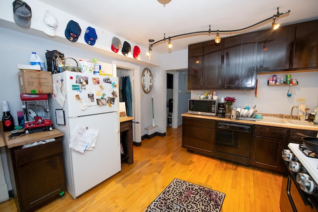 kitchen with dark brown cabinets, sink, light hardwood / wood-style floors, and white appliances