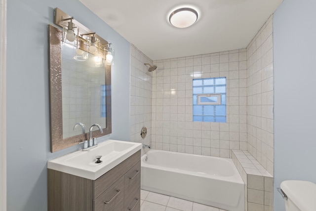 full bathroom featuring tiled shower / bath combo, vanity, toilet, and tile floors