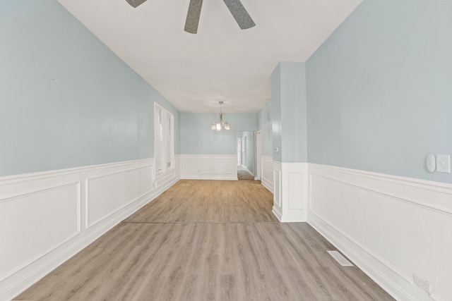 corridor with light hardwood / wood-style flooring and a chandelier