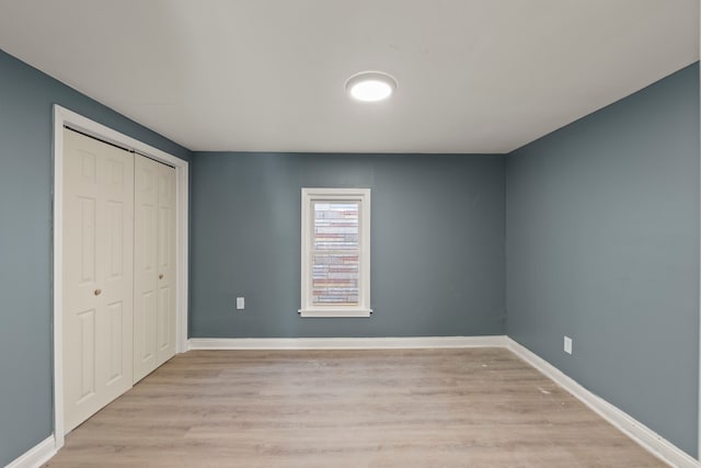 unfurnished bedroom featuring a closet and light hardwood / wood-style floors