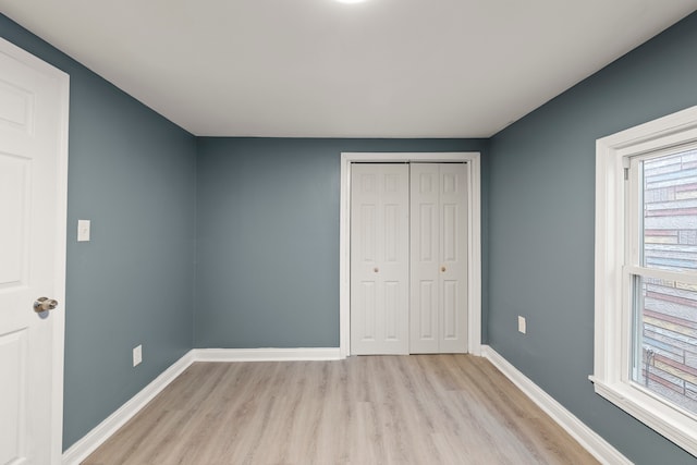 unfurnished bedroom featuring a closet and light wood-type flooring