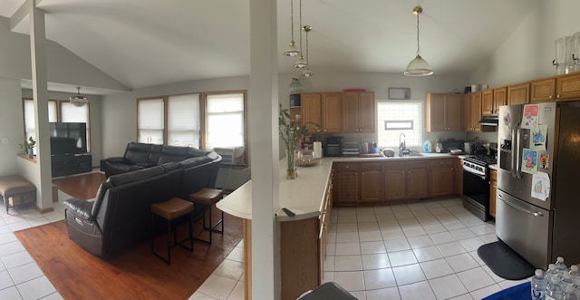 kitchen featuring stainless steel fridge with ice dispenser, hanging light fixtures, stove, and light tile patterned floors