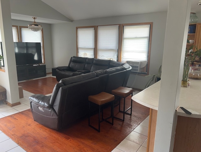 living room with cooling unit, tile patterned flooring, and vaulted ceiling