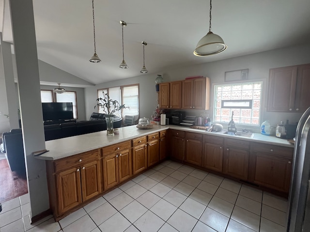 kitchen with hanging light fixtures, light tile patterned flooring, and lofted ceiling