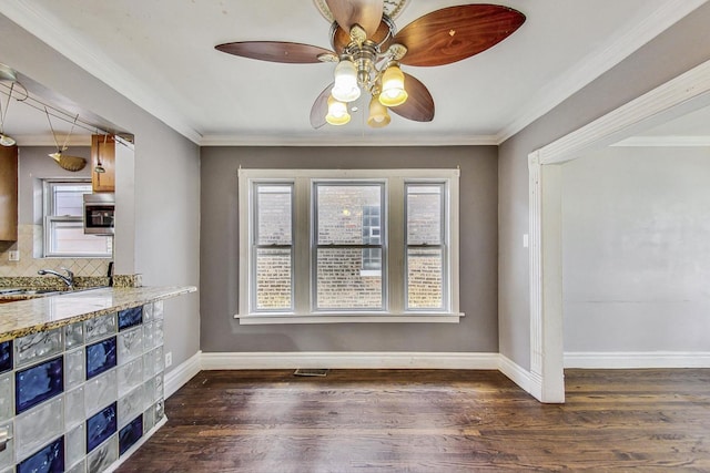 unfurnished dining area with dark hardwood / wood-style floors, a healthy amount of sunlight, and crown molding