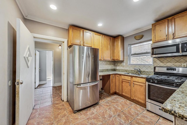 kitchen with decorative backsplash, light stone counters, stainless steel appliances, crown molding, and sink