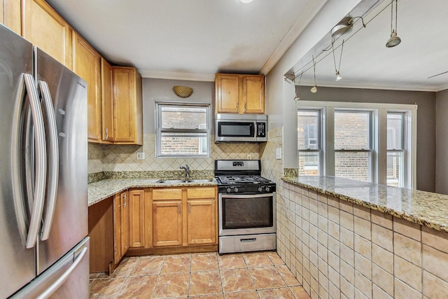 kitchen with light stone countertops, sink, backsplash, appliances with stainless steel finishes, and ornamental molding