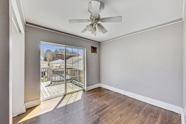 spare room with crown molding, ceiling fan, and dark wood-type flooring