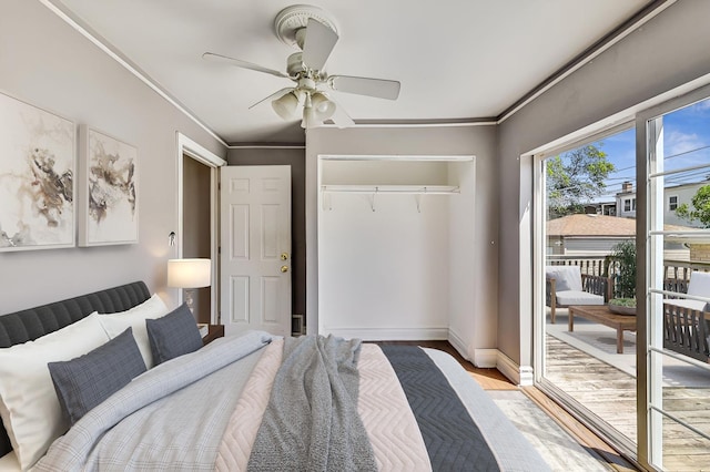 bedroom featuring light wood-type flooring, a closet, ornamental molding, and ceiling fan