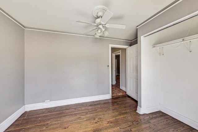 unfurnished bedroom featuring crown molding, ceiling fan, a closet, and dark wood-type flooring