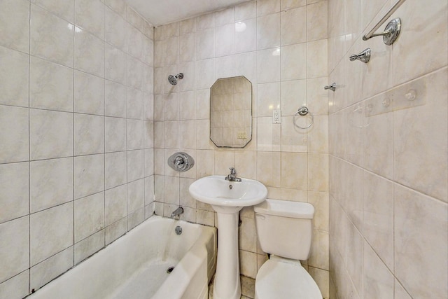 bathroom with toilet and tile walls