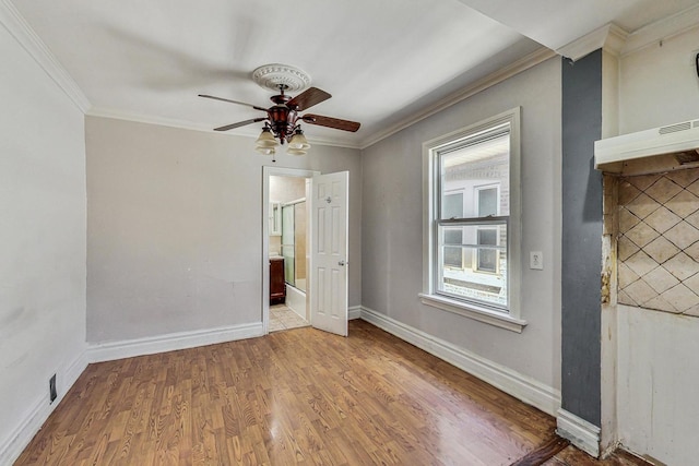 empty room featuring ceiling fan, wood-type flooring, and crown molding