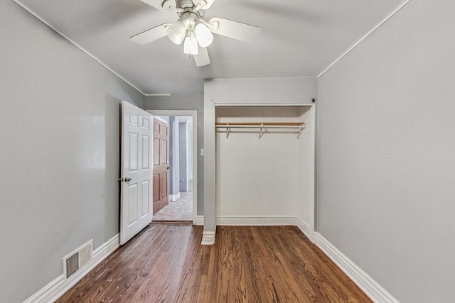 unfurnished bedroom with ceiling fan, a closet, and dark hardwood / wood-style floors