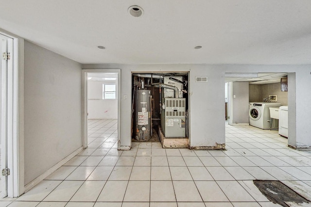 interior space featuring heating unit, gas water heater, and washer / dryer