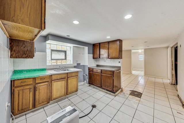 kitchen featuring light tile patterned floors, backsplash, and sink