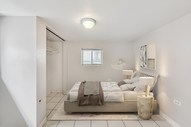 bedroom with light tile patterned flooring and a closet