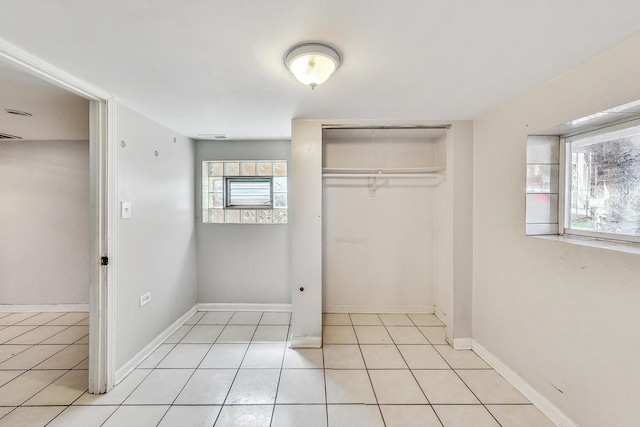 unfurnished bedroom featuring light tile patterned floors and a closet