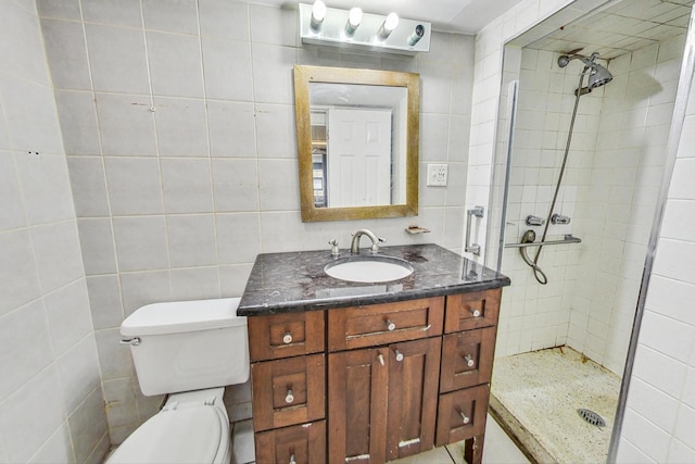 bathroom featuring tiled shower, vanity, toilet, and tile walls