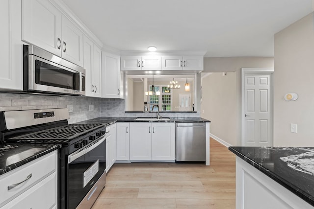 kitchen with stainless steel appliances, white cabinetry, and a sink