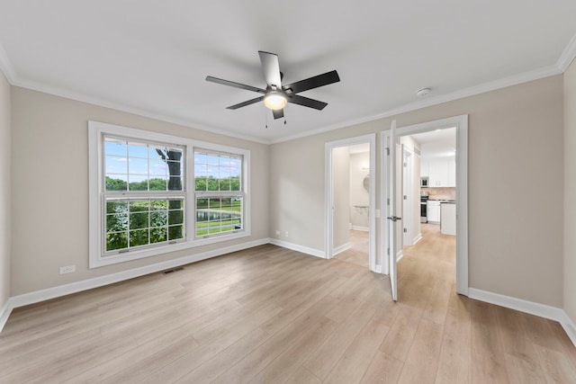 unfurnished room featuring light wood-style floors, baseboards, visible vents, and ornamental molding