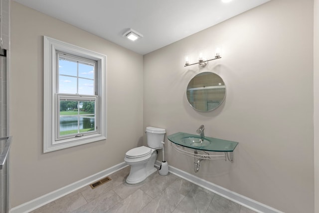 bathroom with toilet, visible vents, baseboards, and tile patterned flooring