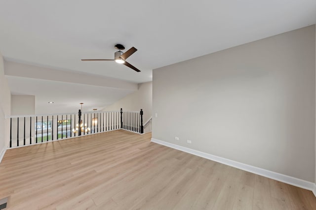 empty room featuring ceiling fan, light wood-style floors, lofted ceiling, and baseboards