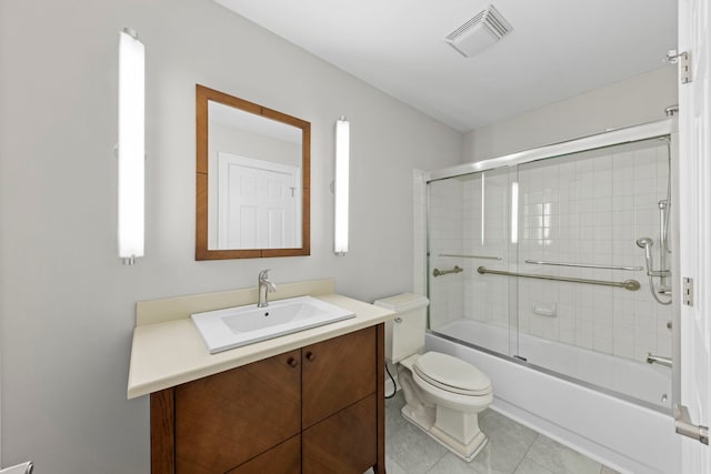 bathroom with shower / bath combination with glass door, visible vents, toilet, vanity, and tile patterned flooring