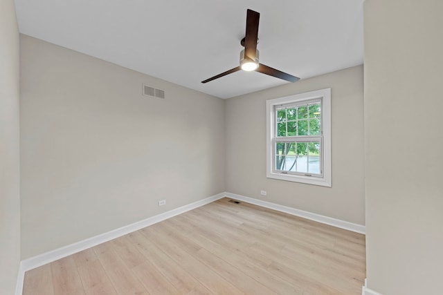 spare room featuring light wood-style floors, visible vents, baseboards, and a ceiling fan