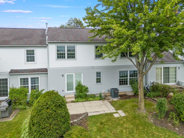 rear view of property featuring a yard, a patio, and central AC unit