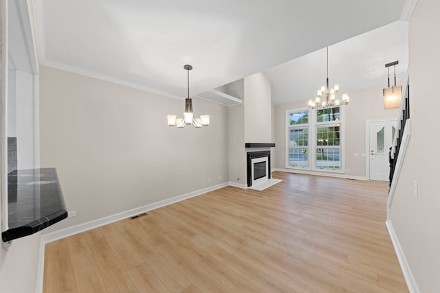 unfurnished living room featuring baseboards, a fireplace with flush hearth, light wood-style flooring, and a notable chandelier