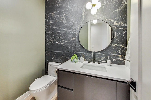 bathroom featuring vanity, tile walls, and toilet