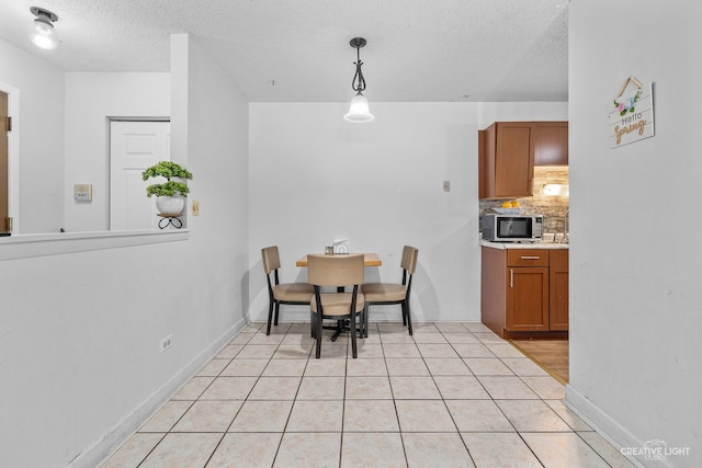 tiled dining area featuring a textured ceiling