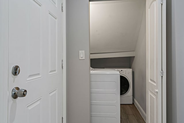 washroom with laundry area, baseboards, stacked washer and clothes dryer, and wood finish floors