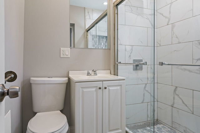 bathroom with toilet, a shower stall, and vanity