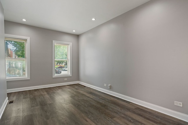 spare room featuring dark wood-style floors, recessed lighting, visible vents, and baseboards