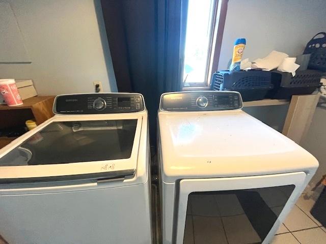 laundry room with washer and dryer and light tile patterned flooring