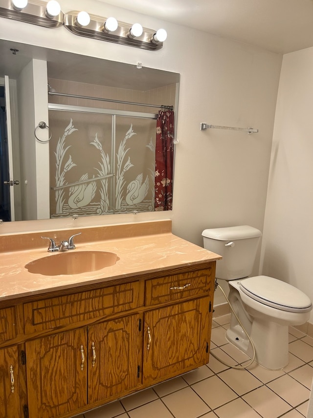 bathroom with tile flooring, vanity, and toilet